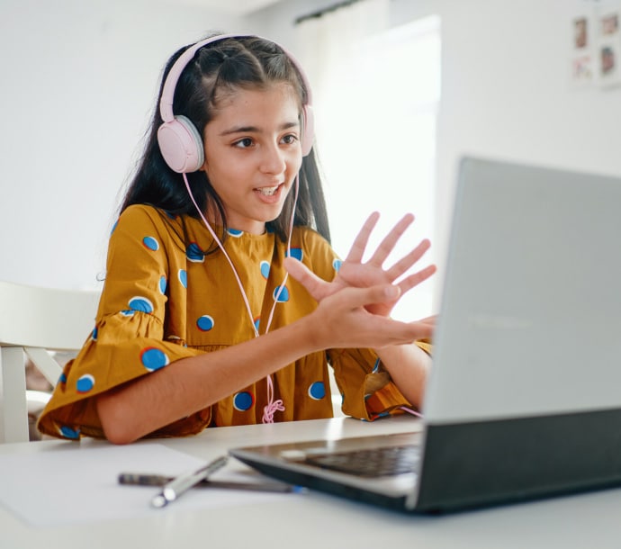 girl on desk using laptop launching Norton Family.