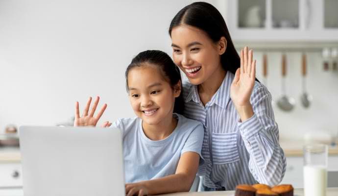 Woman and daugther waving at laptop