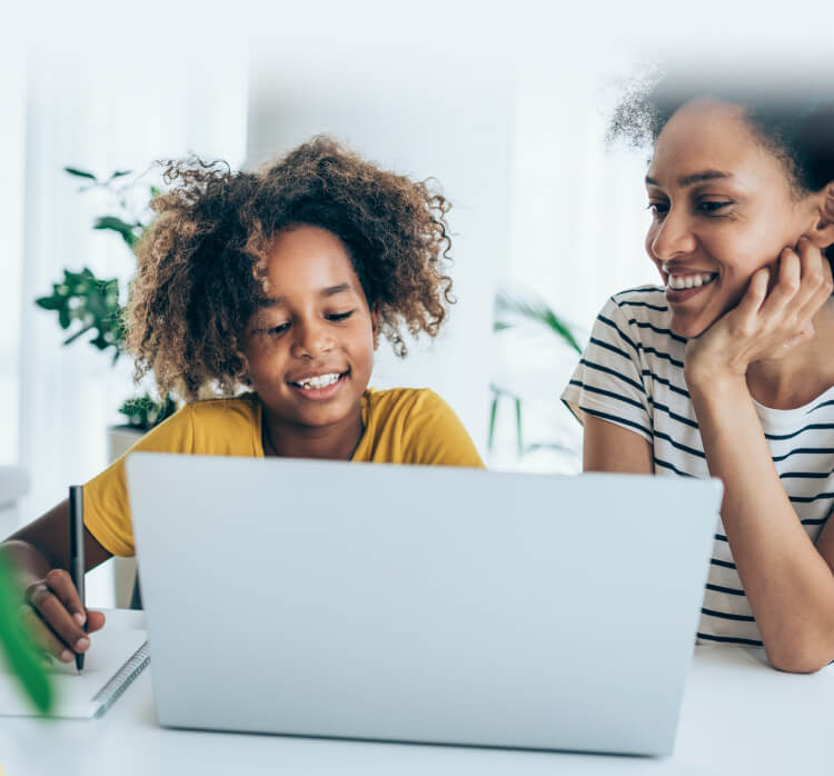 Mother and daughter using laptop lauching Norton Family.